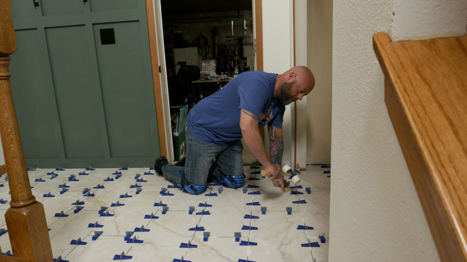 using a mallet to remove the leveling system